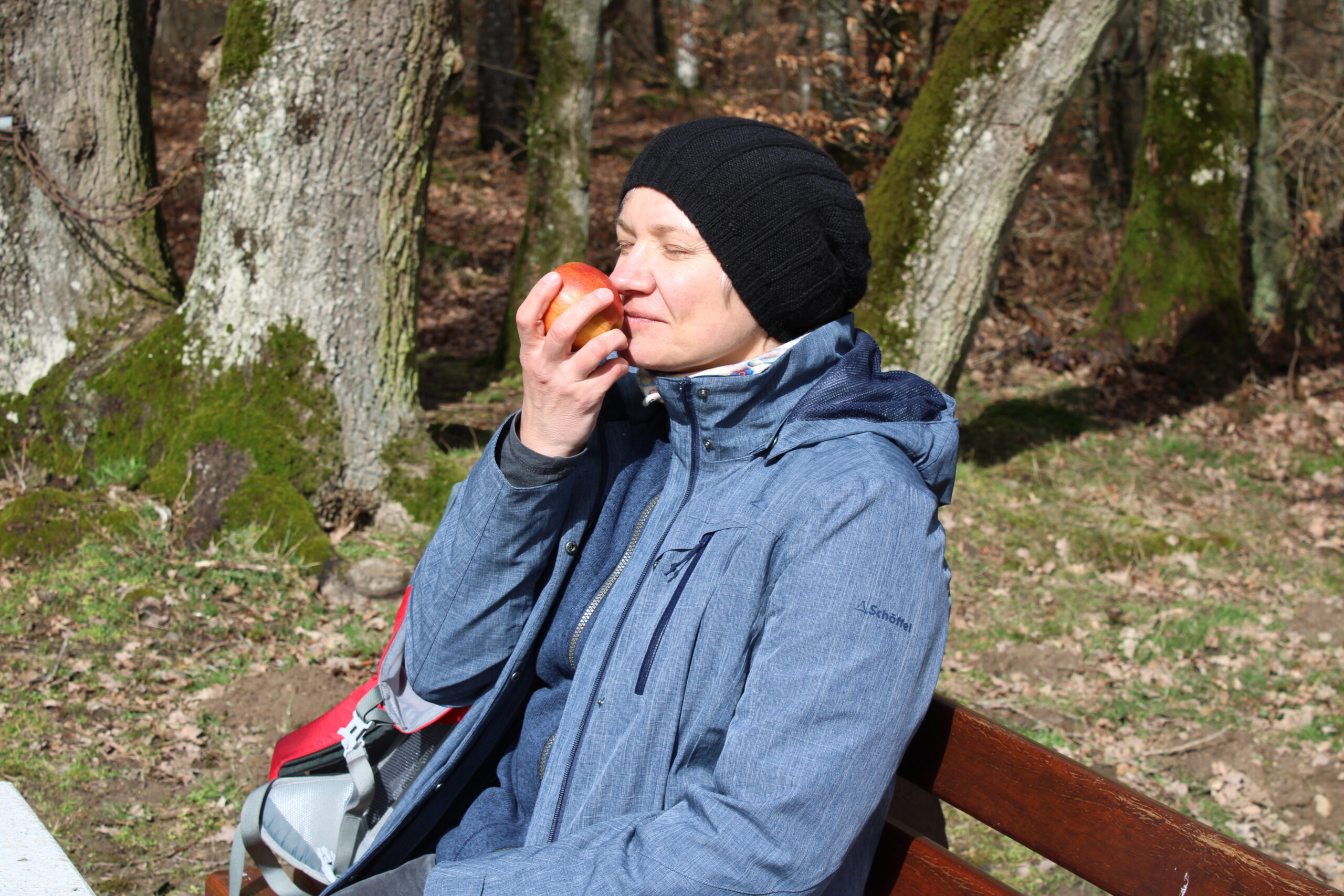 Person riecht genussvoll an einem Apfel